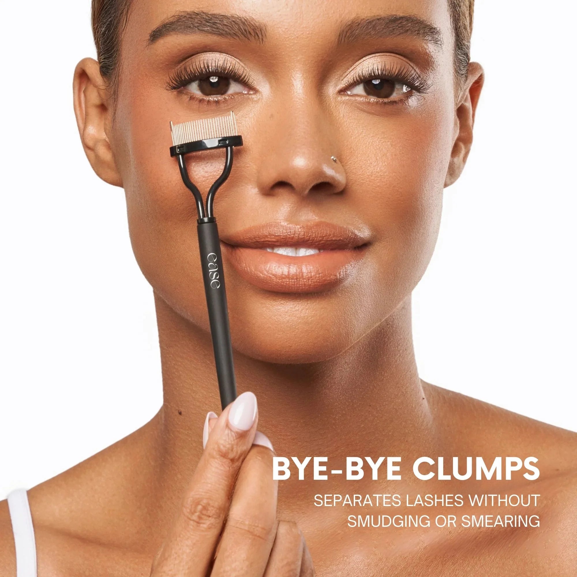 Woman holding a lash comb with text 'BYE-BYE CLUMPS' on a white background